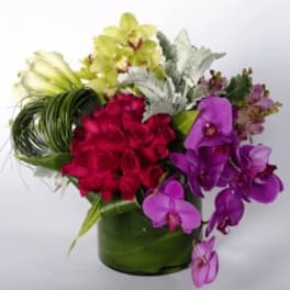 Bouquet of orchids and red roses in a green vase
