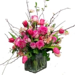 Pink roses and tulips in a clear glass vase