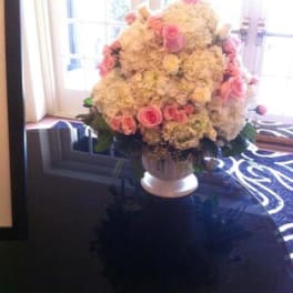 Pink and white floral arrangement in a pedestal vase