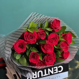 Bouquet of red roses wrapped in striped paper