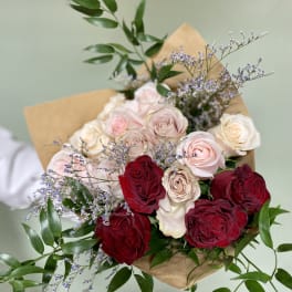 Bouquet of red, blush, and cream roses with purple filler flowers
