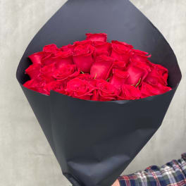 Bouquet of red roses wrapped in black paper