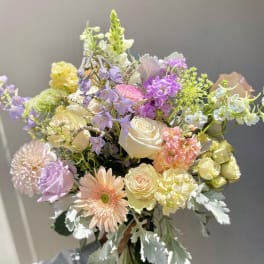 Hand-tied bouquet of pastel roses, gerbera daisies, and mixed blooms