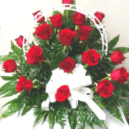 Basket arrangement of red roses with a white ribbon bow