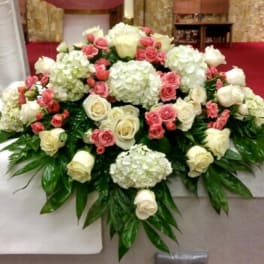 Large white and pink rose arrangement with hydrangeas on a table
