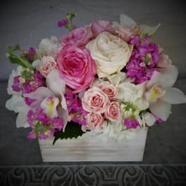 Pink and white rose bouquet in a white wooden box with orchid blooms