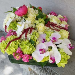 Mixed floral arrangement with white roses, green hydrangeas, and white orchids