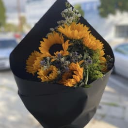 Bouquet of orange sunflowers wrapped in black paper
