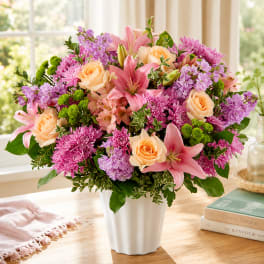 Pink and peach flower arrangement in a white vase