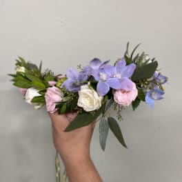 Handheld bouquet of lavender and pink flowers with greenery