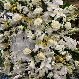 Large white floral spray with lilies, roses, and orchids