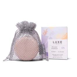 Shower steamer in a mesh pouch beside its retail box