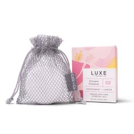 A mesh gift bag beside a pink box labeled shower steamer.