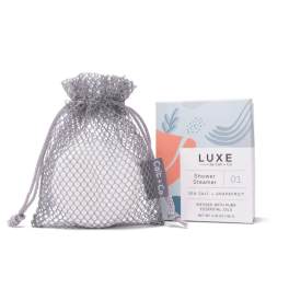 Mesh drawstring bag with a boxed shower steamer