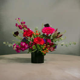 Red roses and pink gerbera daisies in a black vase
