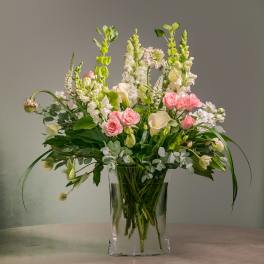 Pink roses and white flowers in a clear glass vase