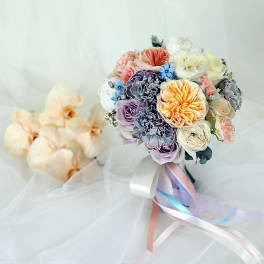 Pastel bouquet with roses and carnations tied with ribbon