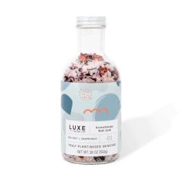 Bottle of aromatherapy bath soak with pink salt and dried petals