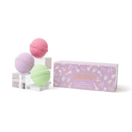 Three pastel bath bombs beside a purple gift box