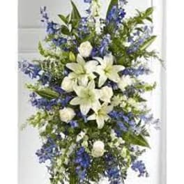 Tall white lily and blue flower standing spray on an easel