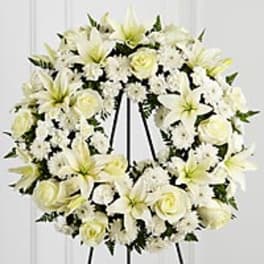 White floral wreath on a black easel stand