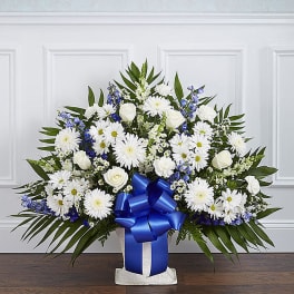 White daisy and rose arrangement with a blue ribbon in a vase