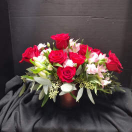 Red roses and pink alstroemeria arranged in a low vase