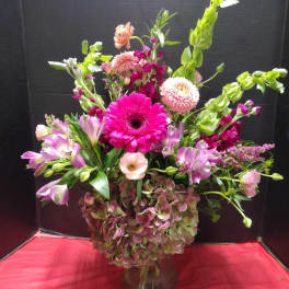 Mixed pink and green flower arrangement in a glass vase