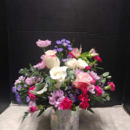Mixed pink, white, and purple bouquet in a patterned glass vase