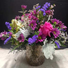 Mixed bouquet with pink rose, purple daisies, and a speckled vase