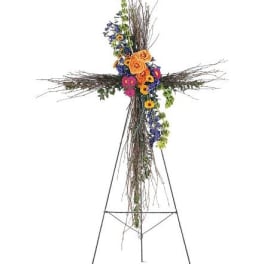 Floral cross on a metal stand with orange, pink, and blue flowers