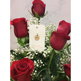 Red roses with baby's breath and a small tag