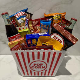 Popcorn bucket filled with soda bottles and assorted snack packs