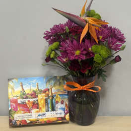 Purple chrysanthemum bouquet in a dark glass vase with an orange ribbon