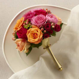 Handheld bouquet of pink, red, and orange roses