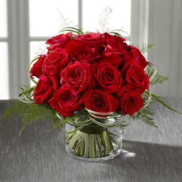 Red roses arranged in a clear glass vase