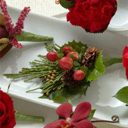 Small floral boutonniere with red berries and greenery on a white tray