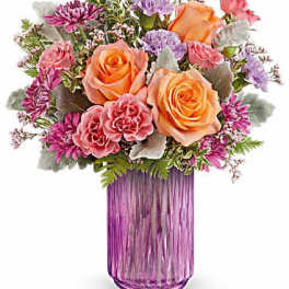 Bouquet of peach and pink roses in a purple glass vase