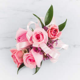 Pink rose corsage with ribbon and small purple flowers