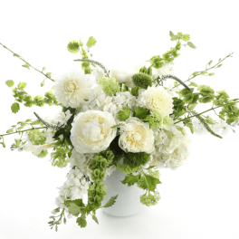 White and green floral arrangement in a white vase