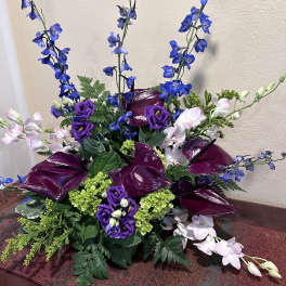 Purple and blue floral arrangement with tall spikes and dark calla lilies