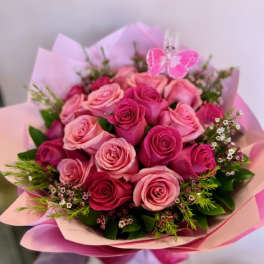 Bouquet of pink and red roses with a butterfly pick