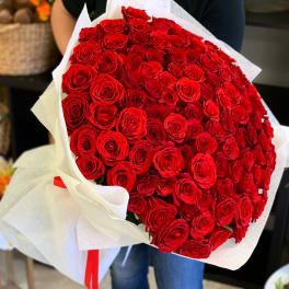 Large bouquet of red roses wrapped in white paper