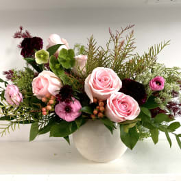 Pink roses and mixed flowers arranged in a white vase