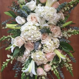 Large white and blush floral spray with lilies and roses on a stand