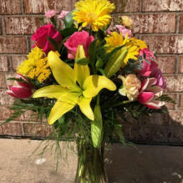 Bouquet of yellow lilies, pink roses, and yellow daisies