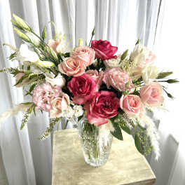 Pink and white rose bouquet in a clear glass vase