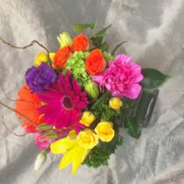 Bright mixed bouquet with gerbera daisies, roses, and carnations in a vase