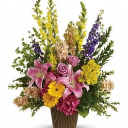 Mixed bouquet of lilies, roses, and daisies in a ribbed vase