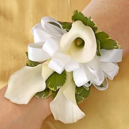 White calla lily wrist corsage with ribbon and green accents